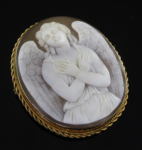 A 9ct gold mounted cameo pendant/brooch carved with an angel with folded arms, 2.25in.